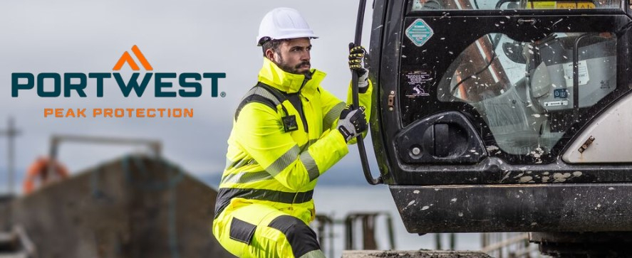 Ein Arbeiter in einem leuchtend gelben Warnschutzanzug mit reflektierenden Streifen, einem weißen Schutzhelm und Handschuhen steigt in eine Baumaschine. Im Hintergrund ist eine Baustellenumgebung mit Baugeräten und grauem Himmel zu sehen. Oben links im Bild befindet sich das Logo von "Portwest" mit dem Slogan "Peak Protection".