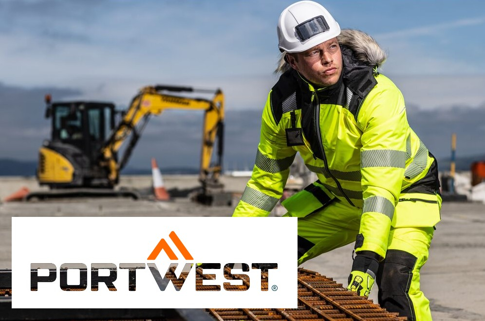 Arbeiter in gelber Winterkleidung und weißem Helm, der ein Eisengitter anhebt. ImHintergrund ist ein Bagger, eine Bergkette und blauer Himmel zu sehen. Im linken unteren Bildrand ist das Logo von Portwest vor weißem Hintergrund. Ein Link zu unseren Winterjacken ist hinterlegt.