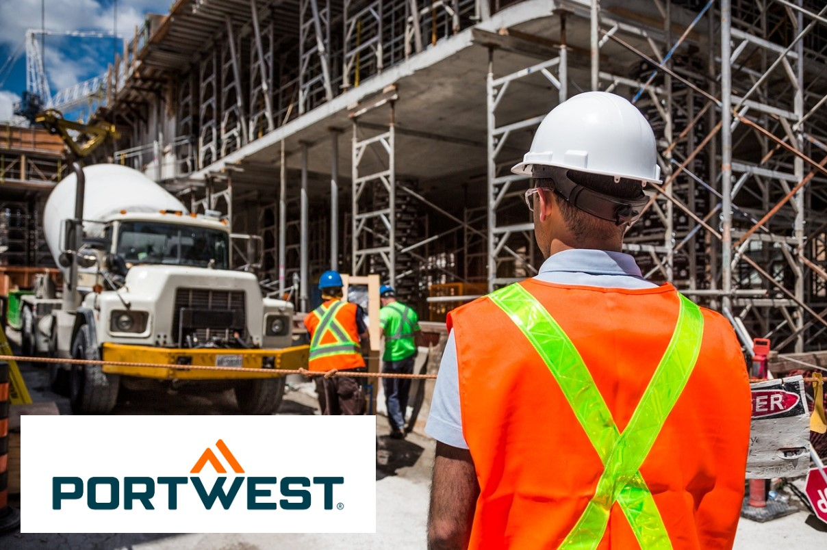 Ein Bauarbeiter mit weißem Schutzhelm und orangefarbener Warnweste mit reflektierenden Streifen steht auf einer Baustelle. Im Hintergrund sind weitere Arbeiter, ein Betonmischer und ein Gerüst zu sehen. Portwest-Logo sichtbar in der Ecke. Ein Link zur Auswahl verschiedener Warnschutz-Kleidung ist hinterlegt.