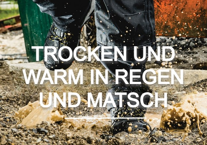 Arbeiter in Regenhose und Stiefeln, der in eine Pfütze läuft. Matsch spritzt, im Hintergrund kann man eine Baustelle erahnen. Hinterlegt ist ein Link zu unseren wasserdichten Schuhen. 