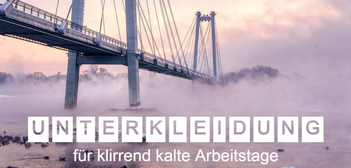 Eine Hängebrücke, die über einen nebligen, zugefrorenen Fluss führt, aufgenommen bei Sonnenaufgang. Der Text "Unterkleidung für klirrend kalte Arbeitstage" ist in großen, weißen Buchstaben über das Bild gelegt. Die Szene vermittelt eine winterliche, frostige Atmosphäre.